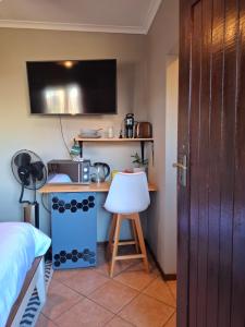 a room with a desk with a microwave and a bed at Cozy City Studio Escape in Centurion