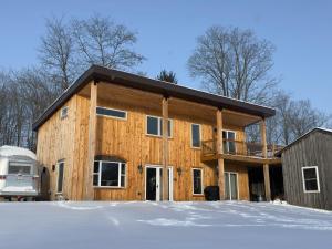 a log home with a deck and a house at Modern Cabin near Watkins Glen in Alpine