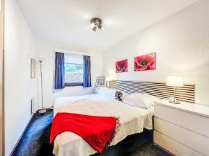 a bedroom with a bed with a red blanket on it at Apartment Martin by Interhome in Frankenau