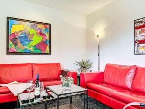 a living room with a red couch and a table at Apartment Martin by Interhome in Frankenau +27 photos