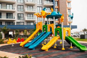 a playground in front of a building at Riverside Life Residence in Trikomo