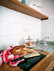 a cutting board with a loaf of bread and a knife at La loge Diane, à deux pas du château et son jardin à la française in Chantilly +13 photos