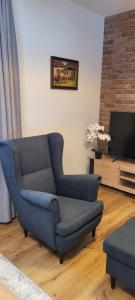 a living room with a blue couch and a tv at Dworek Brzozowy, Augustów Płaska in Płaska