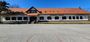 a building with an empty parking lot in front of it at Esterházy Fogadó in Gánt