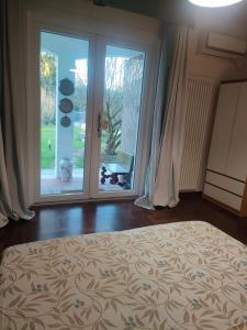 una camera da letto con un letto e una grande finestra di Villa Miani camera floreale a Silea Altre 3 foto