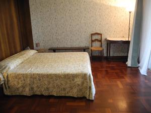 una camera da letto con un letto, una sedia e un tavolo di Villa Miani camera floreale a Silea