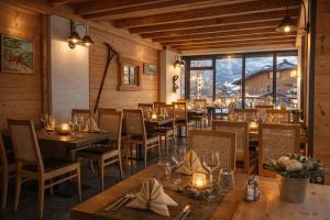 a restaurant with wooden tables and chairs and a large window at Logis Hotel Gai Soleil in Samoëns