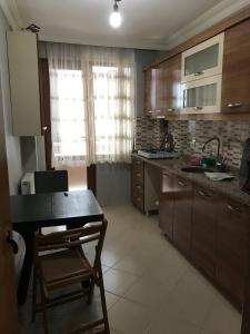 a kitchen with wooden cabinets and a table and a sink at Nefes Evleri in Istanbul