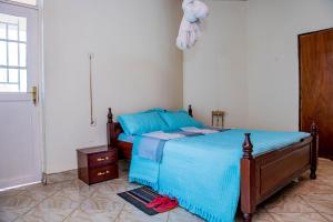 a bedroom with a bed with a blue comforter at Nazareth Guest House in Kigali