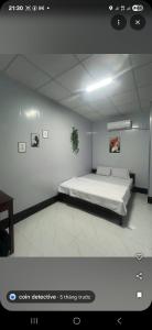 a bedroom with a bed in a white room at Home 100k in Vị Thanh