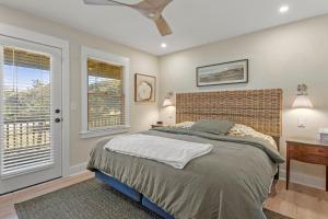 a bedroom with a bed and two windows and a dresser at Boots to Beach in Duck