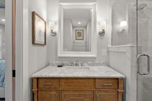 a bathroom with a sink and a shower with a mirror at Boots to Beach in Duck +44 photos