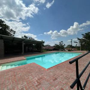 a swimming pool with blue water in front of a building at Ingenia Casa Hostal in Palmira