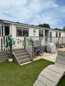 a mobile home with a deck and a fence at Sunset retreat in Crowle