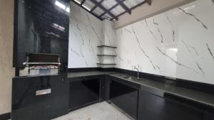 a kitchen with black and white marble walls and a sink at Casa dos Vieira in Marataizes