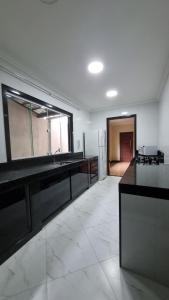a large kitchen with a sink and a refrigerator at Casa dos Vieira in Marataizes
