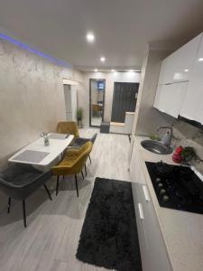 a kitchen and living room with a table and chairs at city apartament in Oradea