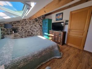 a bedroom with a bed and a stone wall at Maison Le Rêve in Evisa