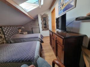 a bedroom with two beds and a flat screen tv at Maison Le Rêve in Evisa