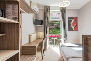 ein Schlafzimmer mit einem Bett und einem Fenster mit einem Tisch in der Unterkunft Hotel Federale in Lugano