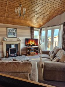 a living room with a couch and a fireplace at Ocean View Lodge - Sea Views & Decking in Ilfracombe