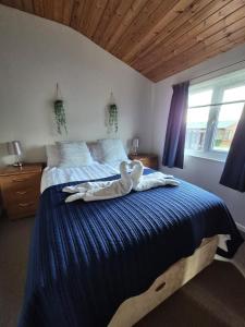 a white swan laying on a bed in a bedroom at Ocean View Lodge - Sea Views & Decking in Ilfracombe