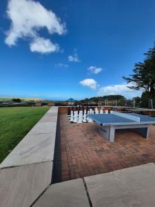 a ping pong table on a brick walkway at Ocean View Lodge - Sea Views & Decking in Ilfracombe