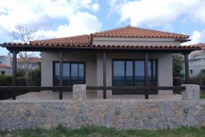 a small house with a stone wall at Villa Agali in Agia Anna