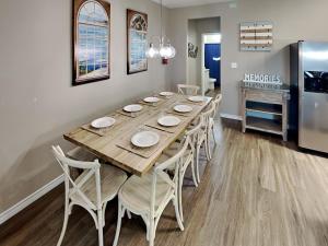 a dining room with a table and chairs and a refrigerator at Hammonds Reef in Padre Island +42 photos