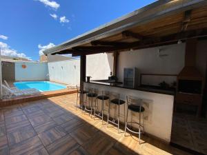 a patio with a bar and a swimming pool at Hotel Acauã in Campo Mourão