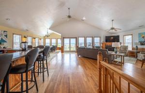 a living room with a couch and chairs and a bar at Paradise Found - Nags Head MP 16.5, Oceanfront, Ocean & Sound Views, Pool, Hot Tub, Pets OK in Nags Head