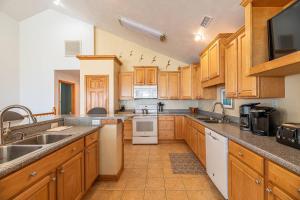 a large kitchen with wooden cabinets and appliances at Paradise Found - Nags Head MP 16.5, Oceanfront, Ocean & Sound Views, Pool, Hot Tub, Pets OK in Nags Head