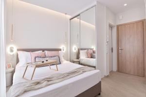 a bedroom with a bed with a table on it at Elan Suites Preveza in Preveza +23 photos