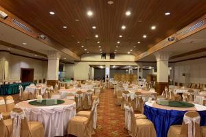 a banquet hall with white tables and chairs at Pailyn Hotel Phitsanulok in Phitsanulok