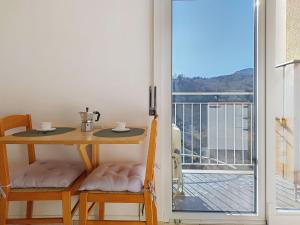 a table and chairs with a table and a balcony at Apartment Euroville-2 by Interhome in Germignaga