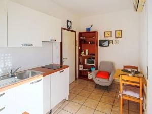 a kitchen with a sink and a table and a chair at Apartment Euroville-2 by Interhome in Germignaga