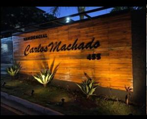 a wooden wall with a sign that reads caritas machias at Casa Matteucci 2 quartos in Londrina