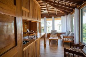 a kitchen with a sink and a living room at Hotel Neptuno Refugio in Boca Chica