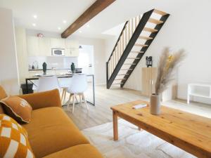 a living room with a couch and a table at AlsAppart, duplex climatisé à 5 min de Colmar in Sainte-Croix-en-Plaine