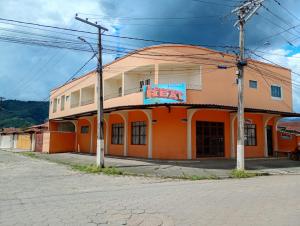 an orange building on the corner of a street at Pousada Real in Itamonte
