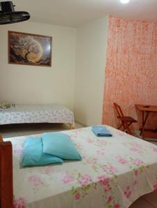 a bedroom with a bed with a pink and blue pillow at Pousada Real in Itamonte