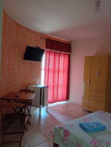 a bedroom with a bed and a table and a desk at Pousada Real in Itamonte +10 photos