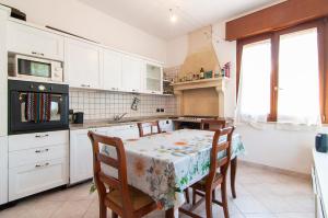 a kitchen with a table with chairs and a stove at Emi&Marti House in Mozzecane +19 photos