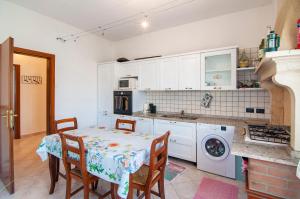 a kitchen with a table and chairs and a stove at Emi&Marti House in Mozzecane