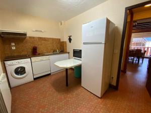 a kitchen with a refrigerator and a washing machine at Appartement spacieux en duplex in Saint-Lary-Soulan