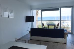 a living room with a couch and a view of the ocean at Faial Marina Apartments 2 in Horta