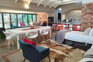 a room with a bed and a table and chairs at Hornbill House Self Catering Accommodation in Hermanus