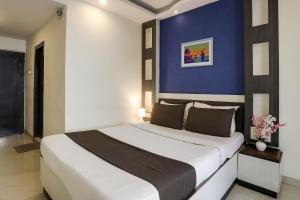 a bedroom with a large bed with a blue wall at Super Capital O Prestige in Hyderabad
