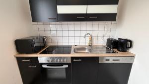 a small kitchen with a sink and a stove at J&R Gästezimmer Kassel in Niestetal