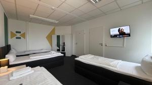 a room with two beds and a flat screen tv at J&R Gästezimmer Kassel in Niestetal